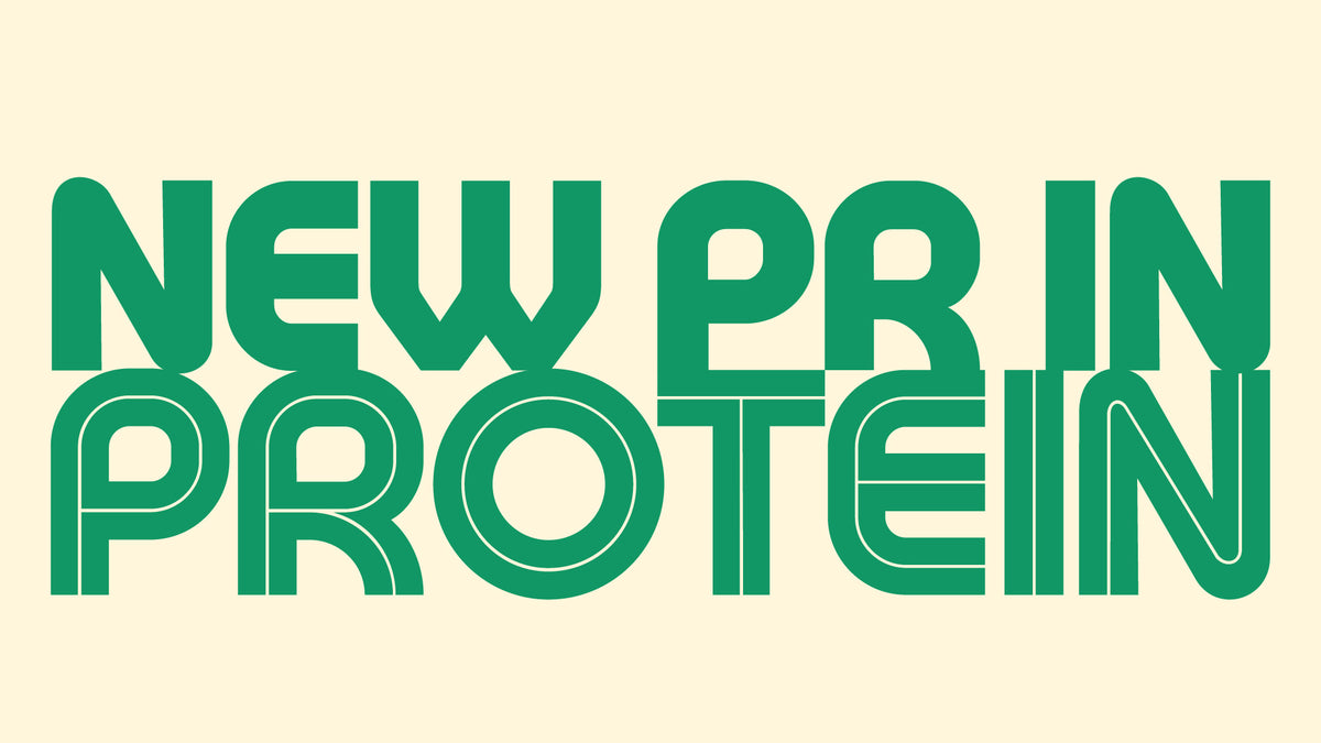“NEW PB IN PROTEIN” in large, bold green retro lettering filling a cream background. “NEW PB IN” is solid, while “PROTEIN” is styled with a thin inner outline.