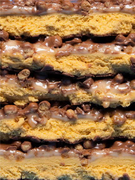 Barebells Cookie Butter protein bar cross-section showing layered cookie dough cake and chocolate peanut butter filling