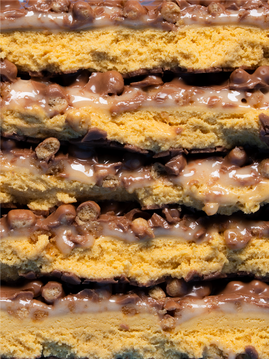 Barebells Cookie Butter protein bar cross-section showing layered cookie dough cake and chocolate peanut butter filling