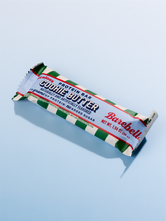 Barebells Cookie Butter protein bar with green and white striped wrapper on light blue background